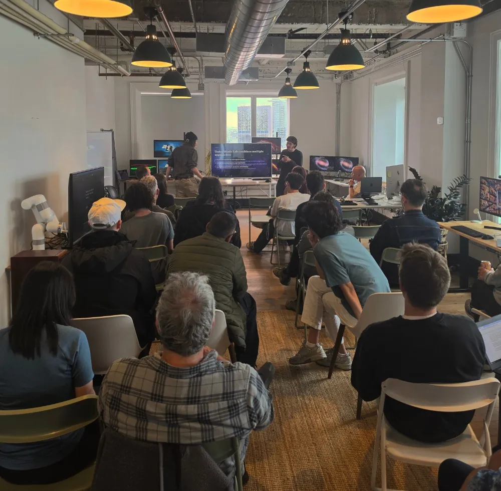 A full room of attendees listening to a presentation at an OtherMinds community evening in the laboratory.
