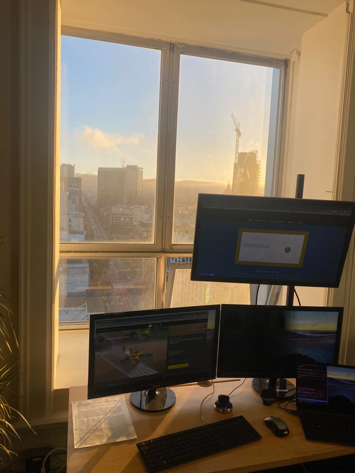 A multi-monitor research workstation at sunset, looking down Market Street from the 15th floor.